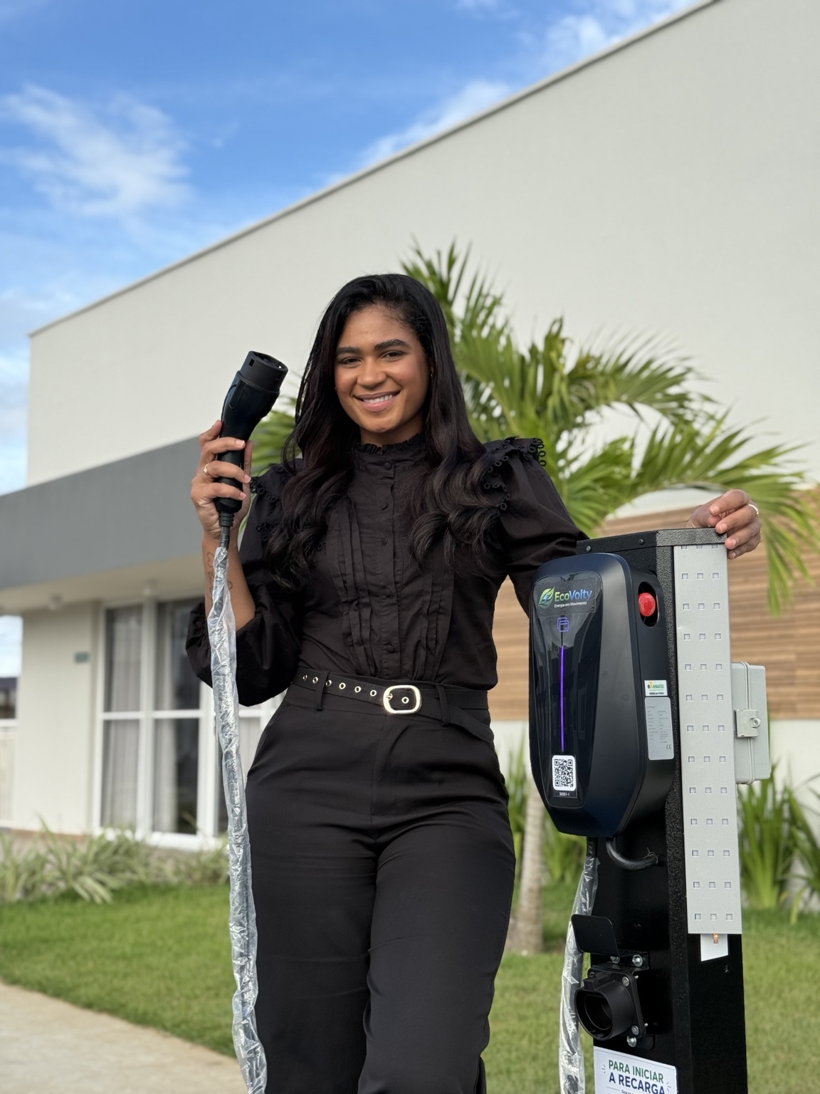 Representante EcoVolty ao lado de carregador veicular instalado